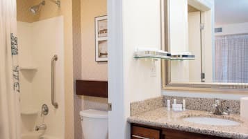 Un baño con ducha, inodoro, lavabo y tocador.