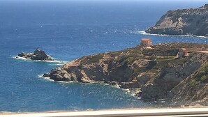 A coastal view with rocky terrain and a building on the right. - Bellevue Village (Malevizi)