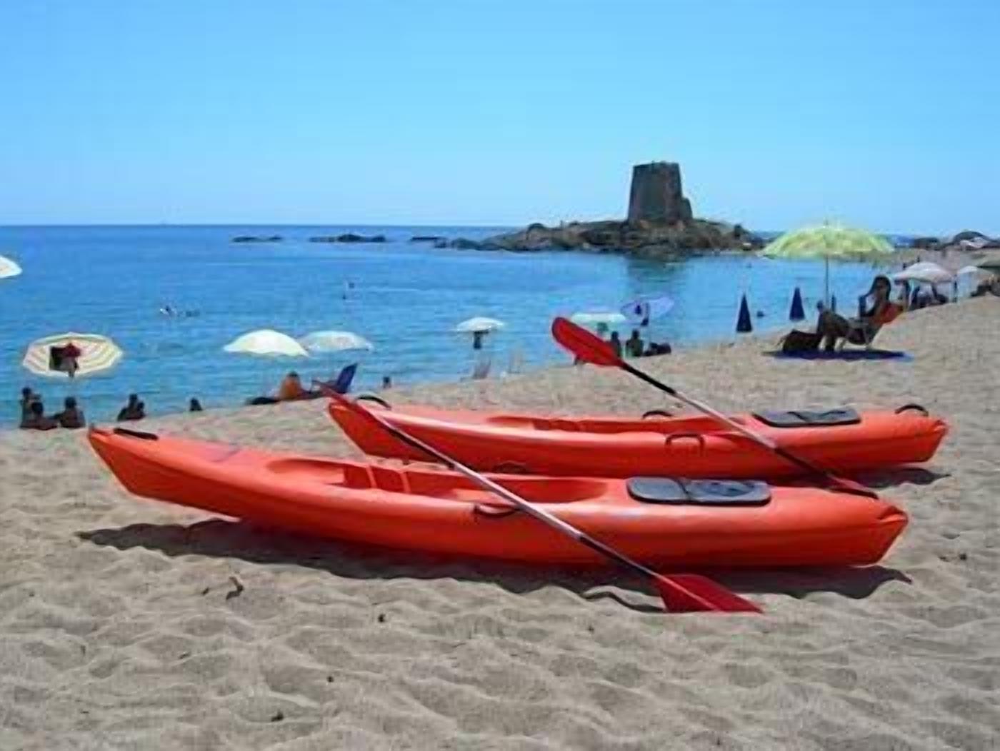 Une plage avec des kayaks et des parasols.