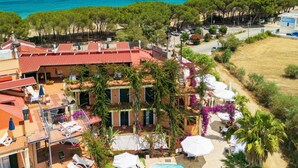 A resort with a swimming pool, outdoor seating, and a view of the sea. - Aparthotel Domus De Janas Sul Mare (Bari Sardo)