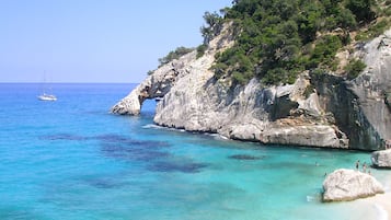 Una playa cerca, arena blanca, sombrillas, buceo