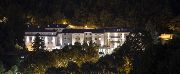 A multi-story hotel with a modern architectural design, surrounded by dense forest. - Hotel Monte Meraviglia (Cascia)