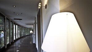 A corridor with a modern lamp, glass doors, and a sign indicating a bar. - Hotel Monte Meraviglia (Cascia)
