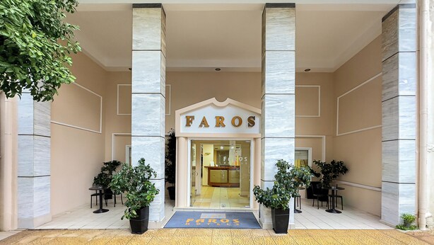 Faros Hotels har en modern entré med en tydlig och välkomnande design, som inkluderar en framträdande ingång, planterade växter och fri sikt in i hotellets interiör.