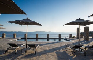 Una piscina al aire libre de temporada, sombrillas