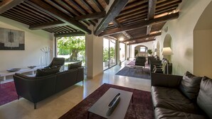 A spacious living area with a modern design, featuring a dark leather sofa, a white coffee table, and a minimalist art piece on the wall. - La Reggia Sporting Center (Cascia)