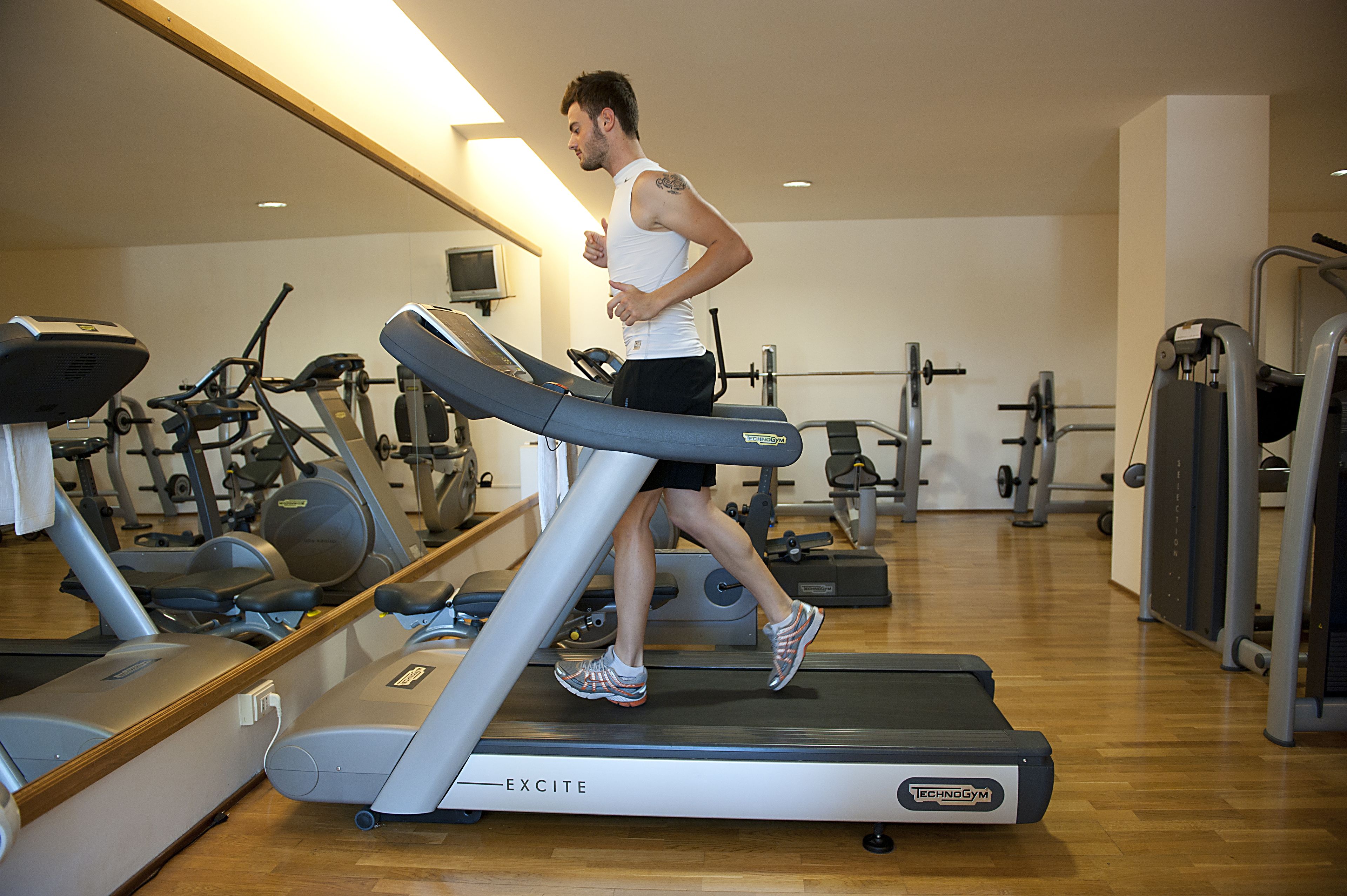 A gym with treadmills, exercise bikes, and weight machines.