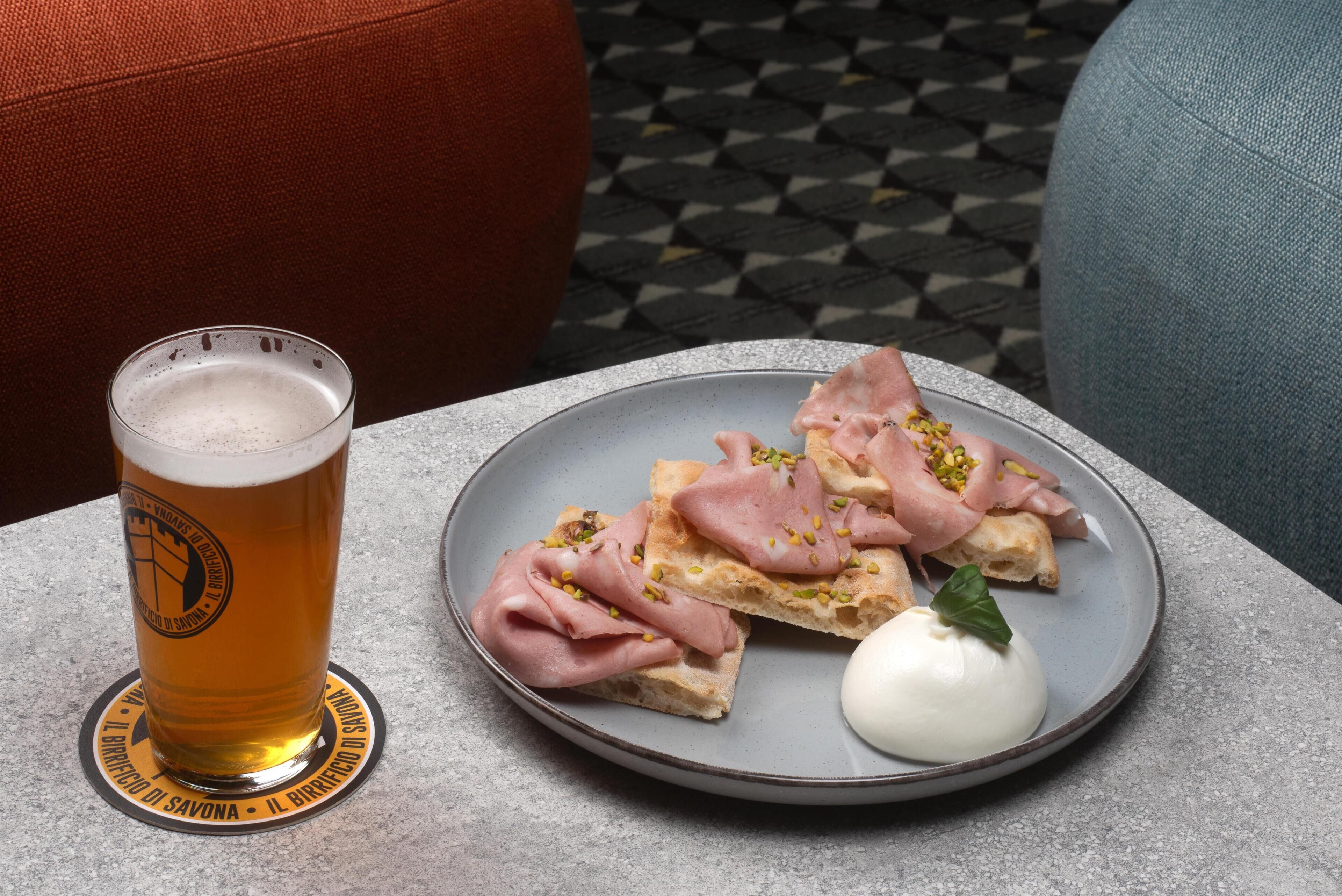 Un plato con comida y una jarra de cerveza sobre una mesa.