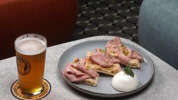 A plate with food and a glass of beer on a table.