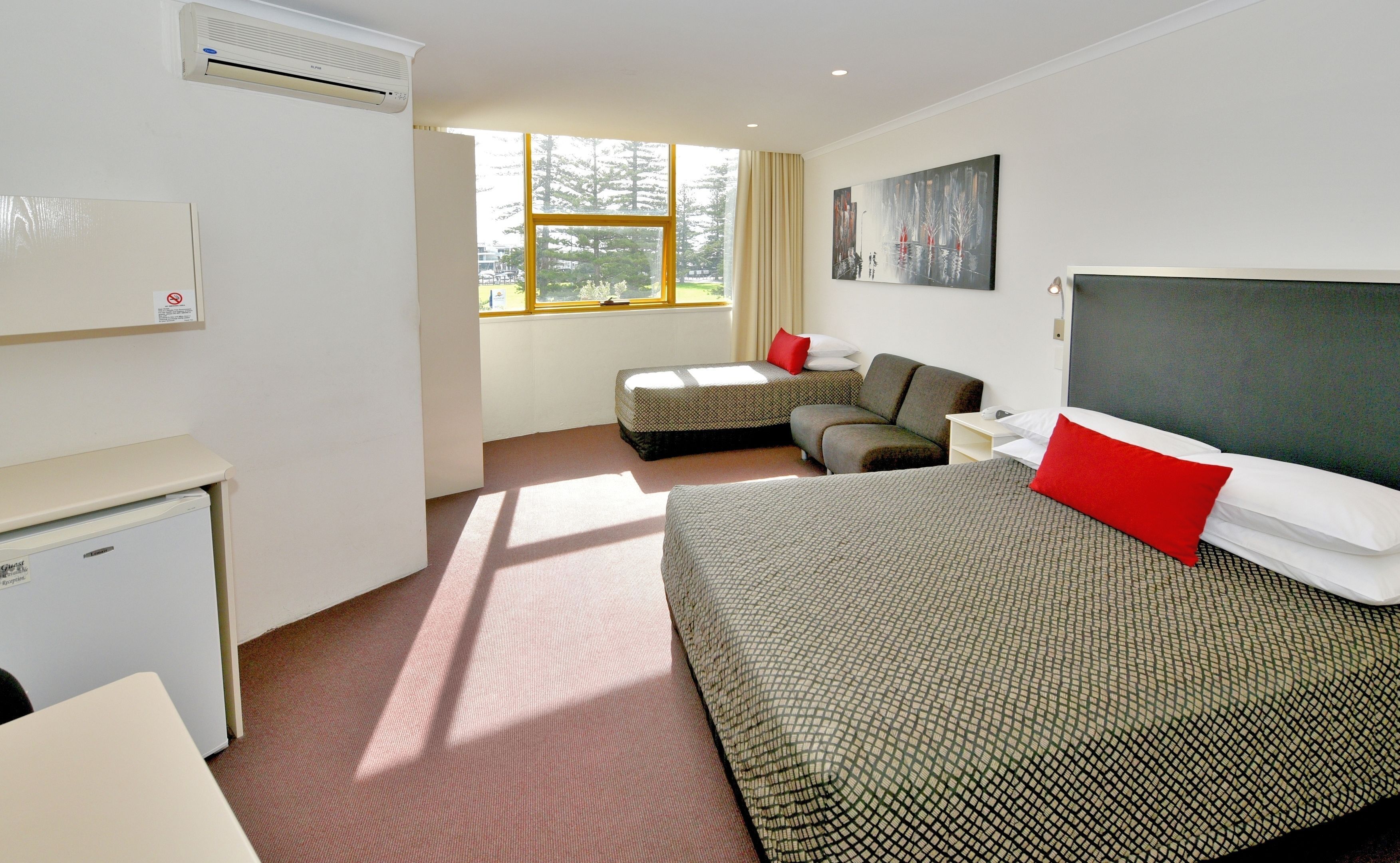 Minibar, escritorio, cortinas blackout y tabla de planchar con plancha 