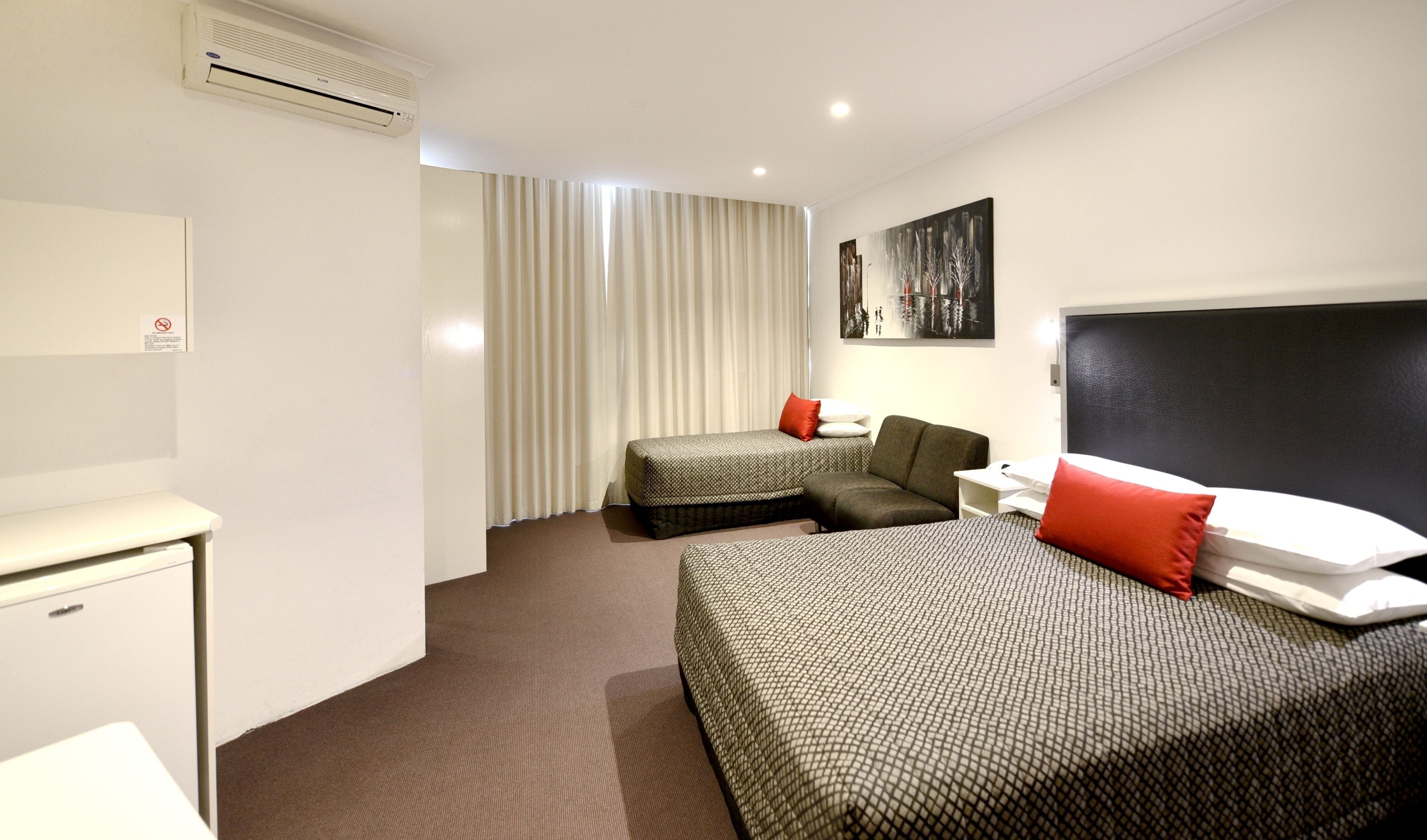 A hotel room with a bed, a sofa, a desk, and a chair.