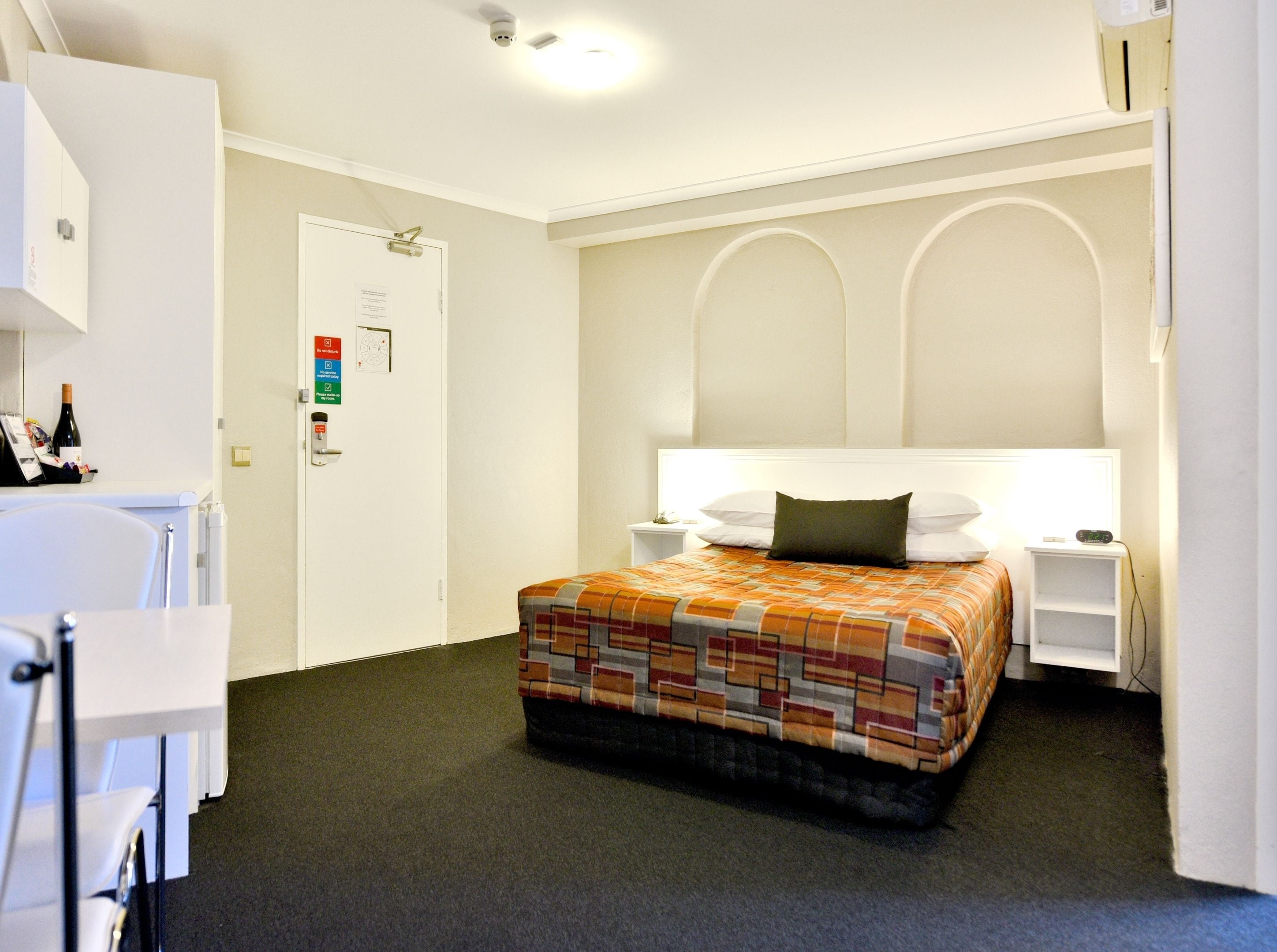 Una habitación de hotel con cama, escritorio y silla.