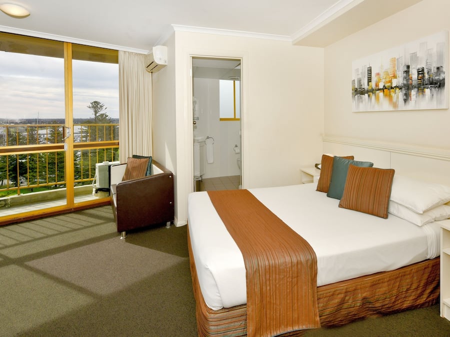 Minibar, escritorio, cortinas blackout y tabla de planchar con plancha