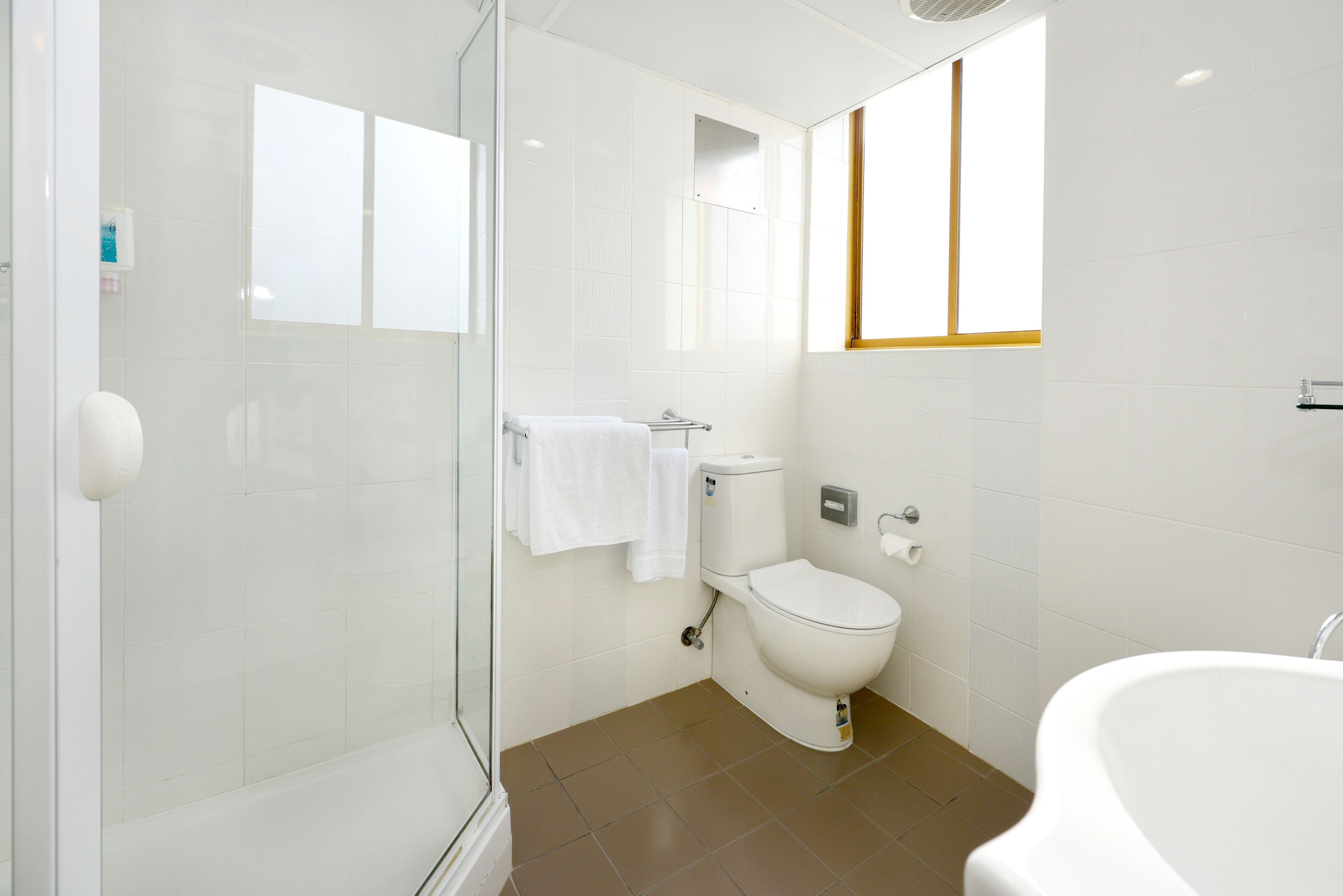 Un baño moderno con cabina de ducha de vidrio, inodoro y bañera.