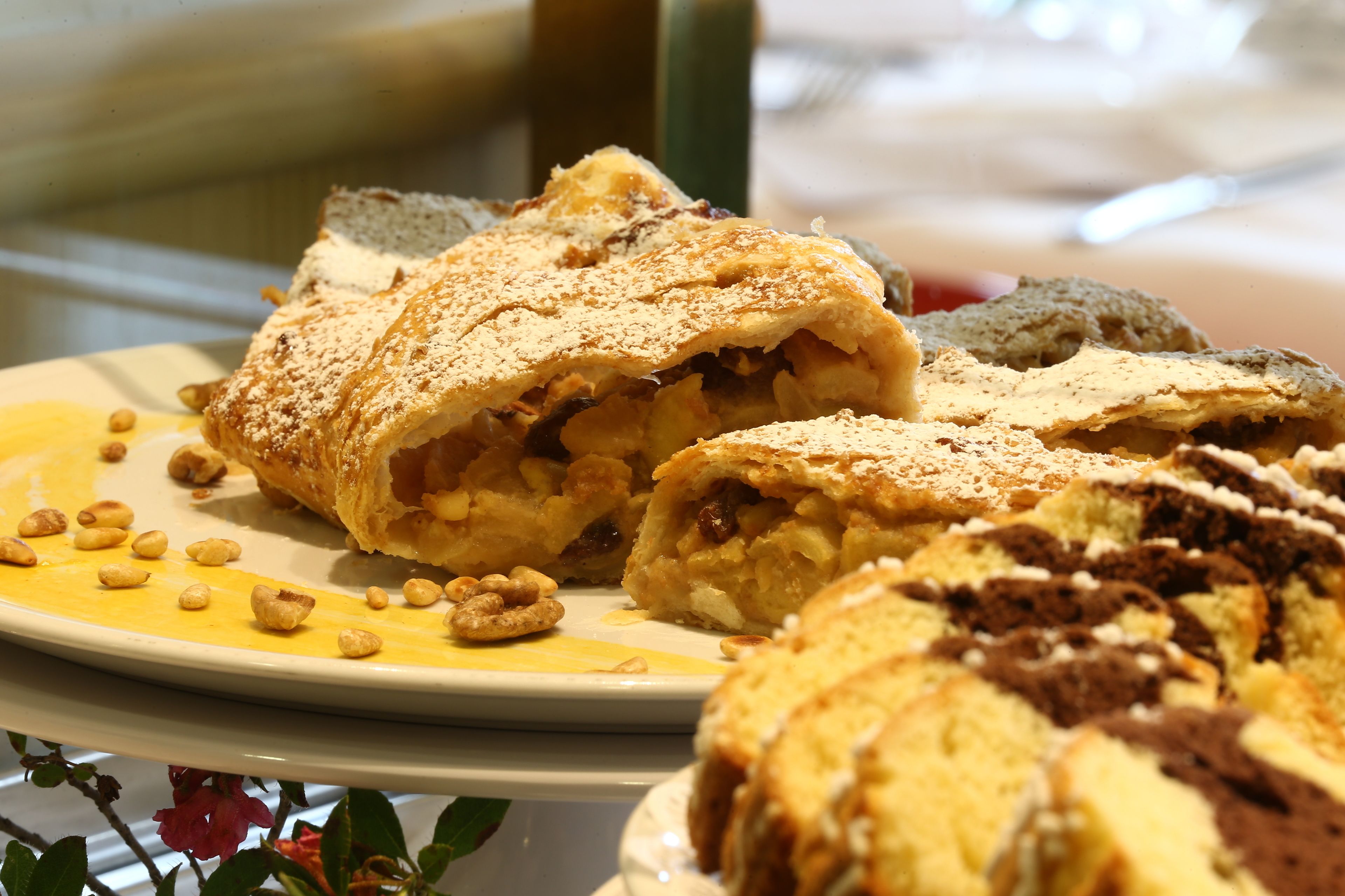 A plate of pastries with nuts and powdered sugar.