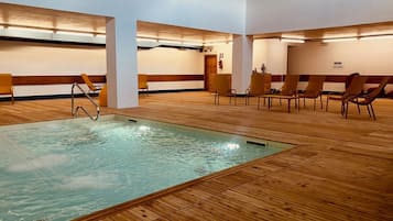 Une chambre d’hôtel avec un plancher en bois, une piscine et des coins salon.