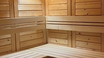 Eine Sauna mit Holzbänken und schrägverdeckter Decke.
