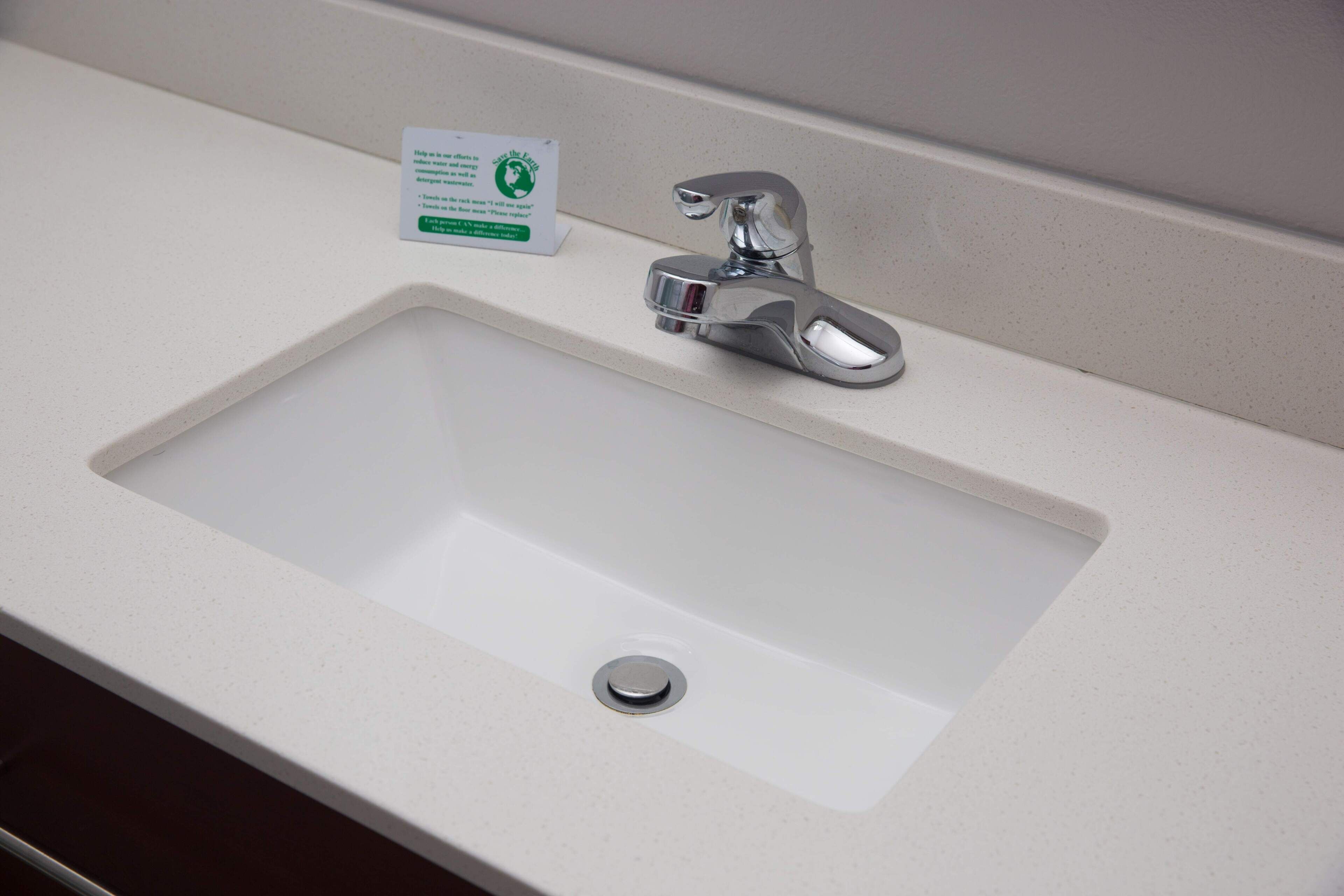 A bathroom sink with a chrome faucet and a drain.