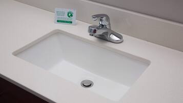 A bathroom sink with a chrome faucet and a drain.