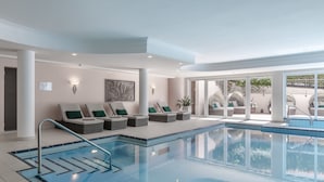 A swimming pool area with lounge chairs and a view of the outside.