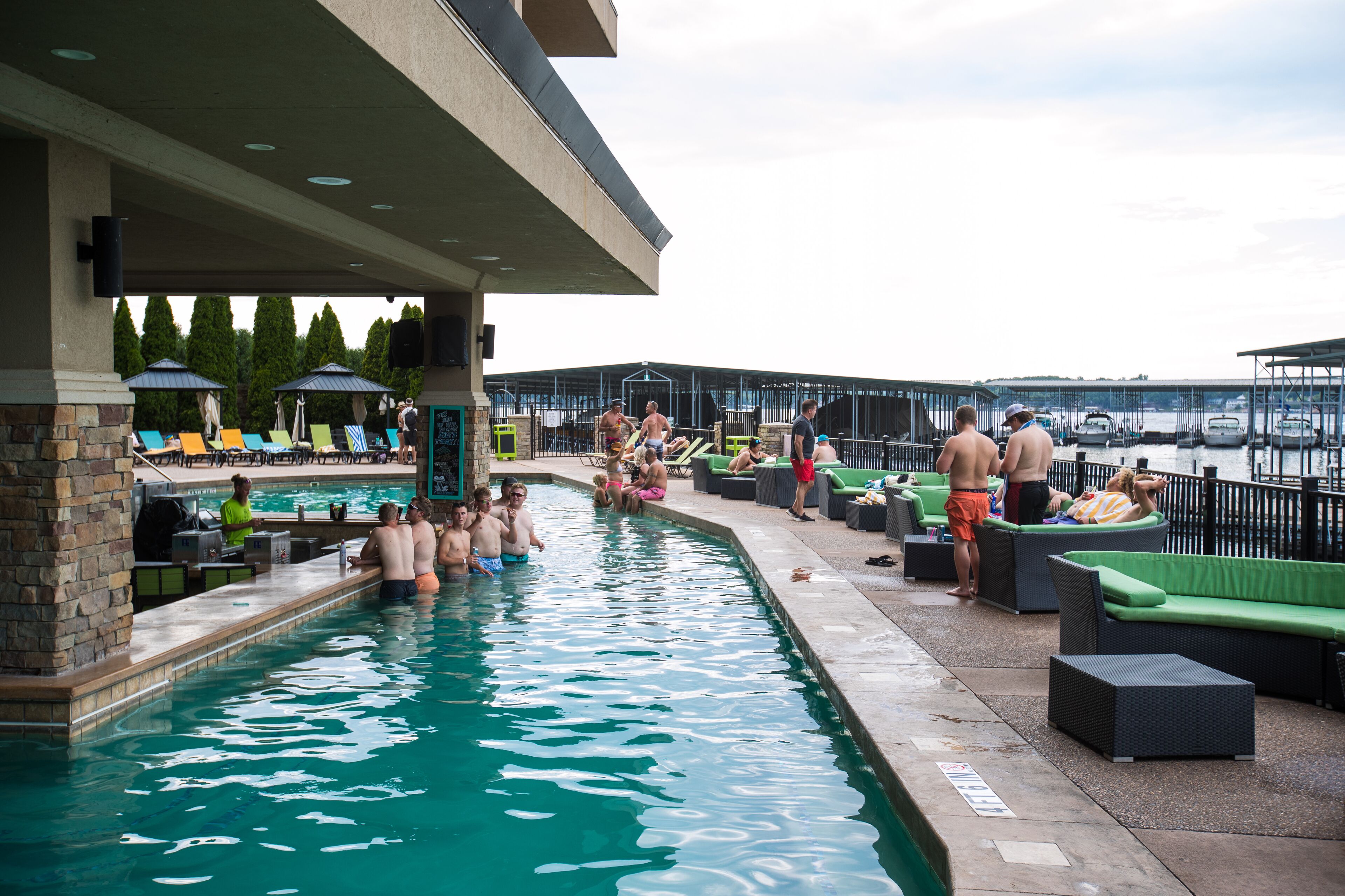 A swimming pool area with lounge chairs and a covered seating area.
