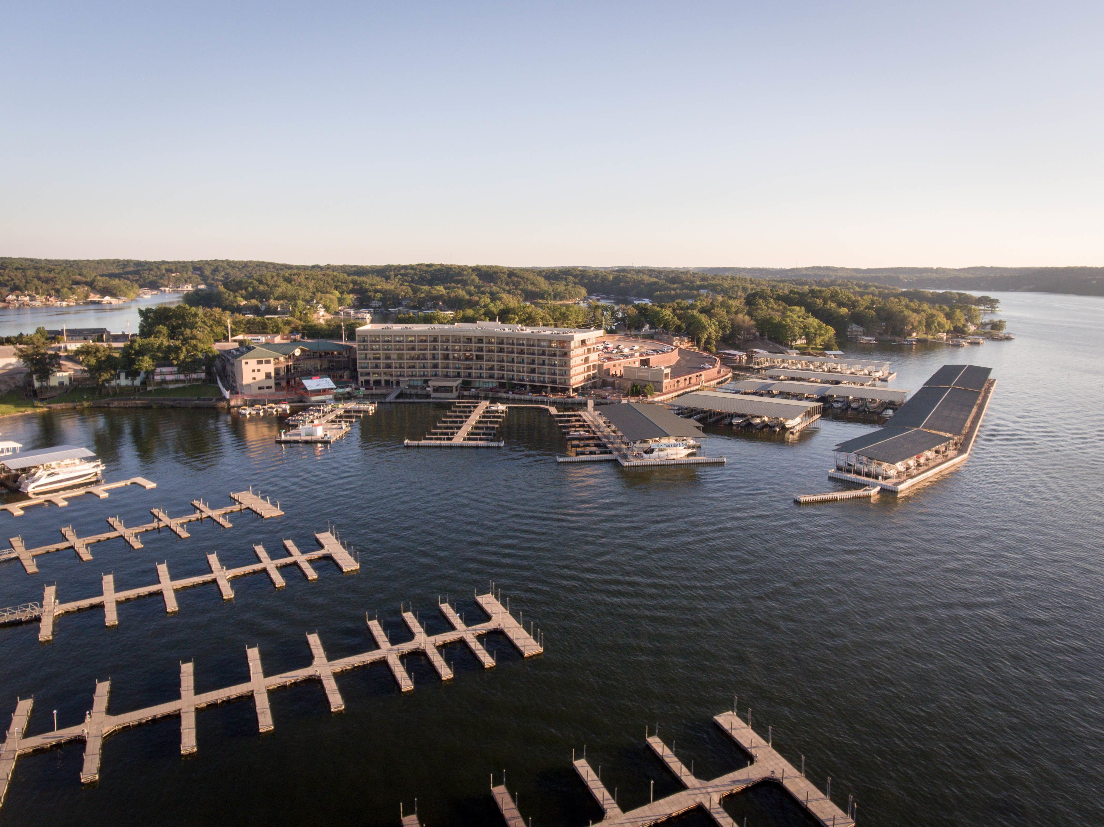 An aerial view of a marina with multiple docks and a large building with a flat roof.