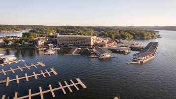 An aerial view of a marina with multiple docks and a large building with a flat roof.