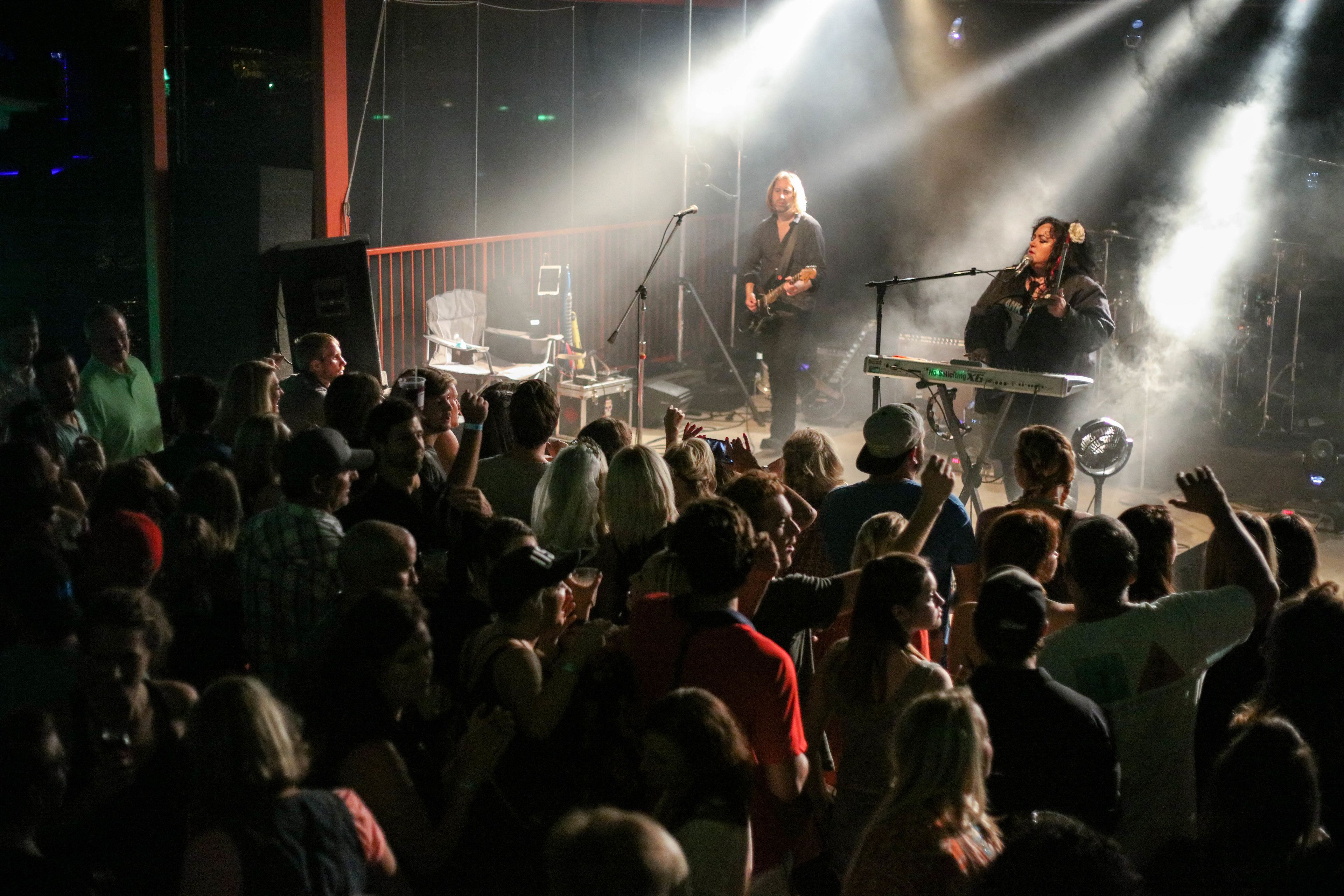 A concert with a crowd of people and musicians on stage.