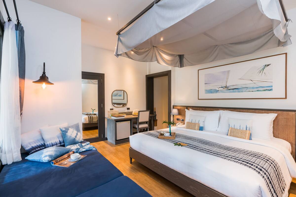 Una habitación de hotel moderna con una cama grande, un escritorio y un dosel.