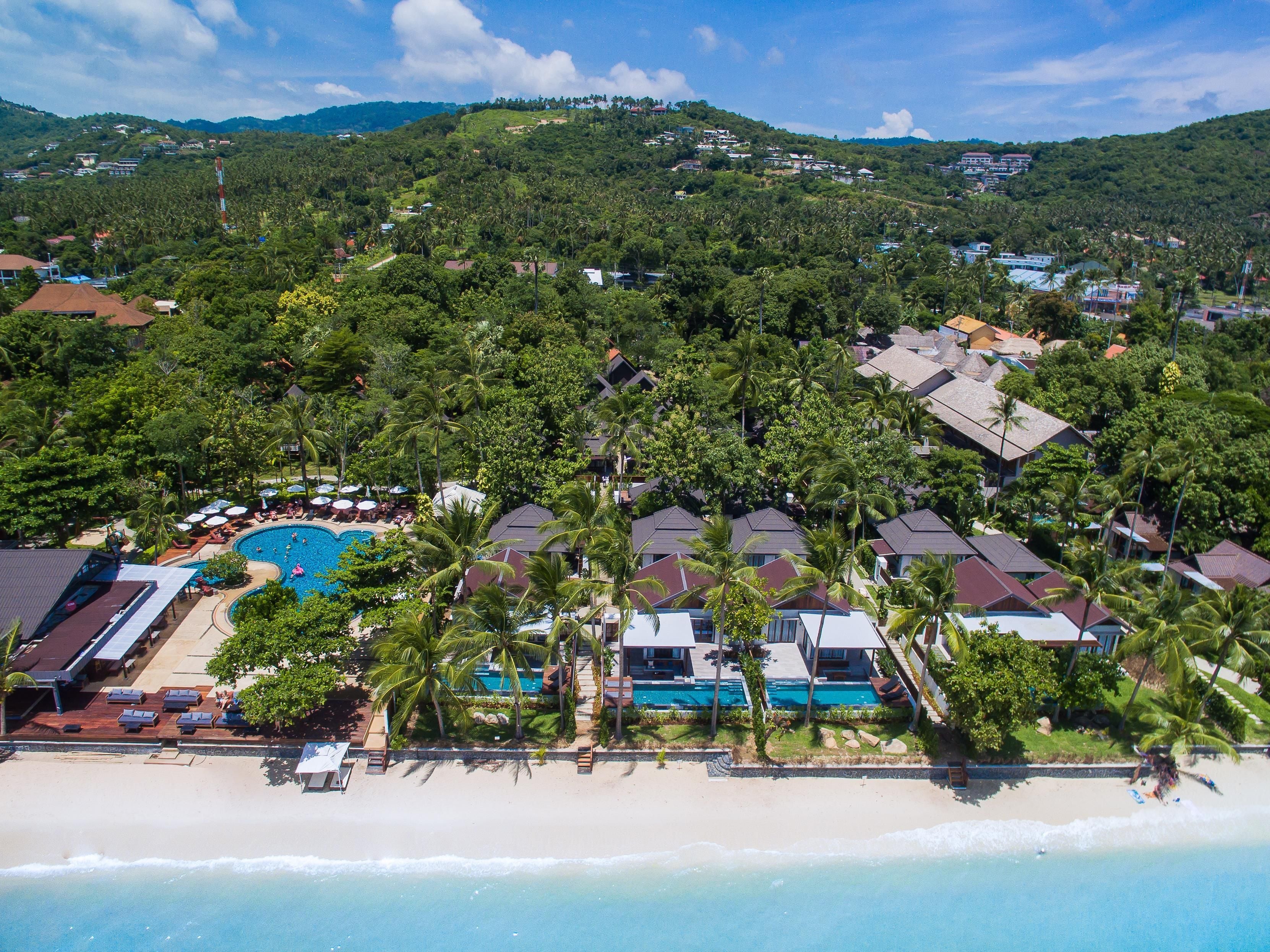 Ein Resort mit Pool, Strand und tropischer Vegetation.