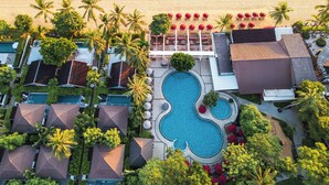 An aerial view of a resort with multiple swimming pools, beachside seating, and palm trees. - NH Collection Samui Peace Resort (Koh Samui)