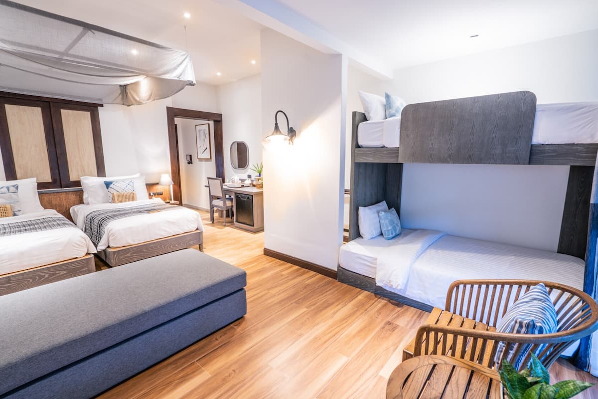 Una habitación con literas, un escritorio y una silla.