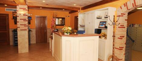 Una cocina amplia con una isla central, vigas de madera en el techo y un muro de ladrillo decorativo.