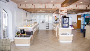 Eine moderne Küche mit Kochinsel, einer Kaffeemaschine und einem Kühlschrank.