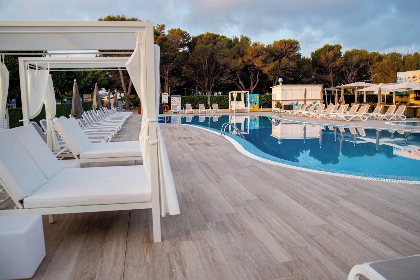 Un espace aménagé au bord de la piscine, avec des chaises longues et un coin salon abrité.