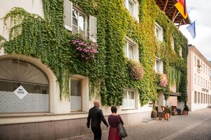 Un edificio con paredes cubiertas de hiedra y un letrero que dice 'KRONE'.