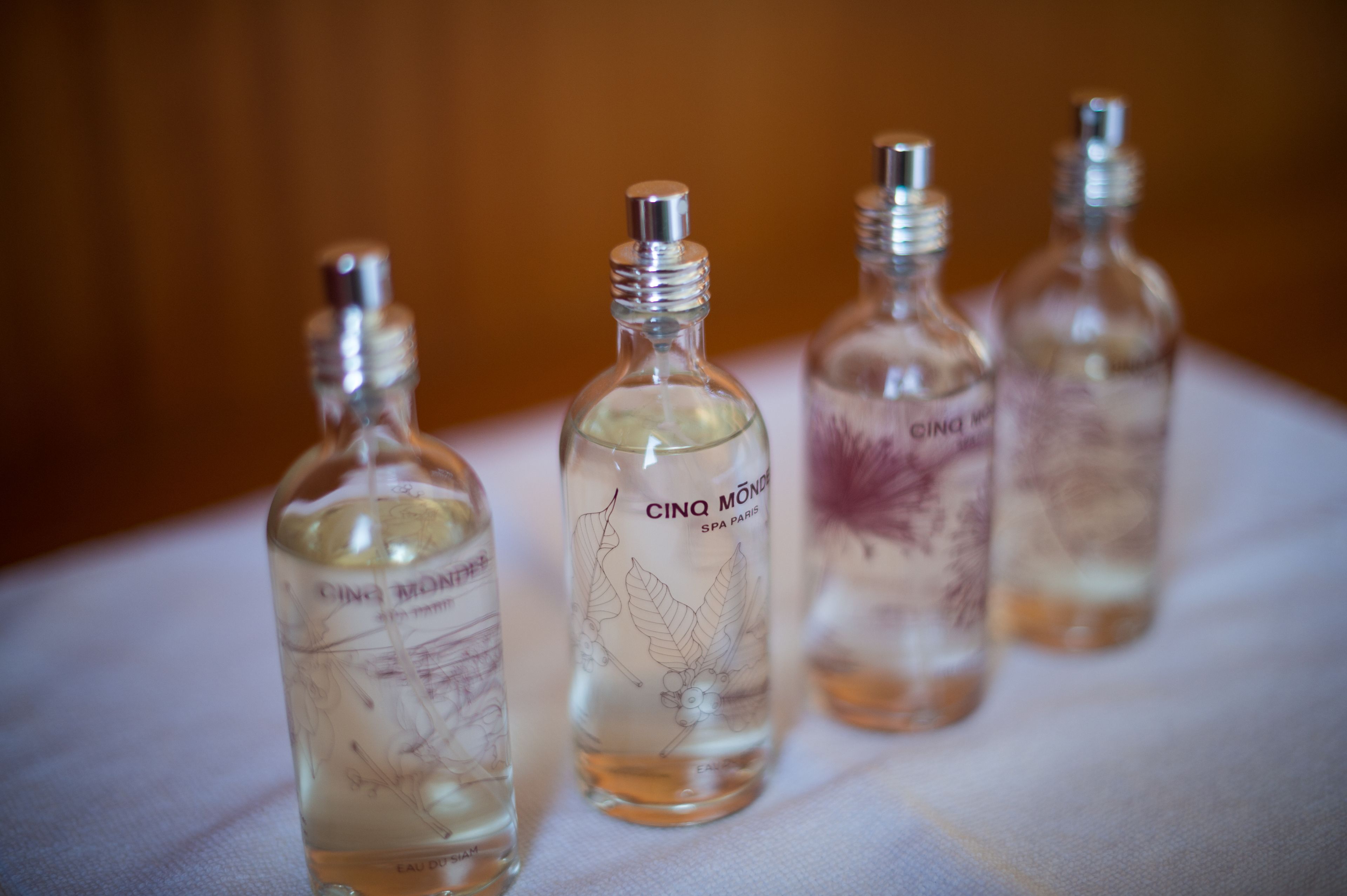 Four bottles of Cinq Mondes spa Paris eau de toilette on a white surface.