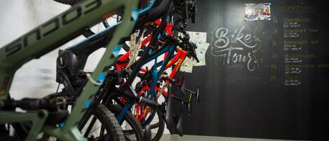 Un servicio de alquiler de bicicletas con una pared que muestra recorridos guiados y tipos de bicicletas.