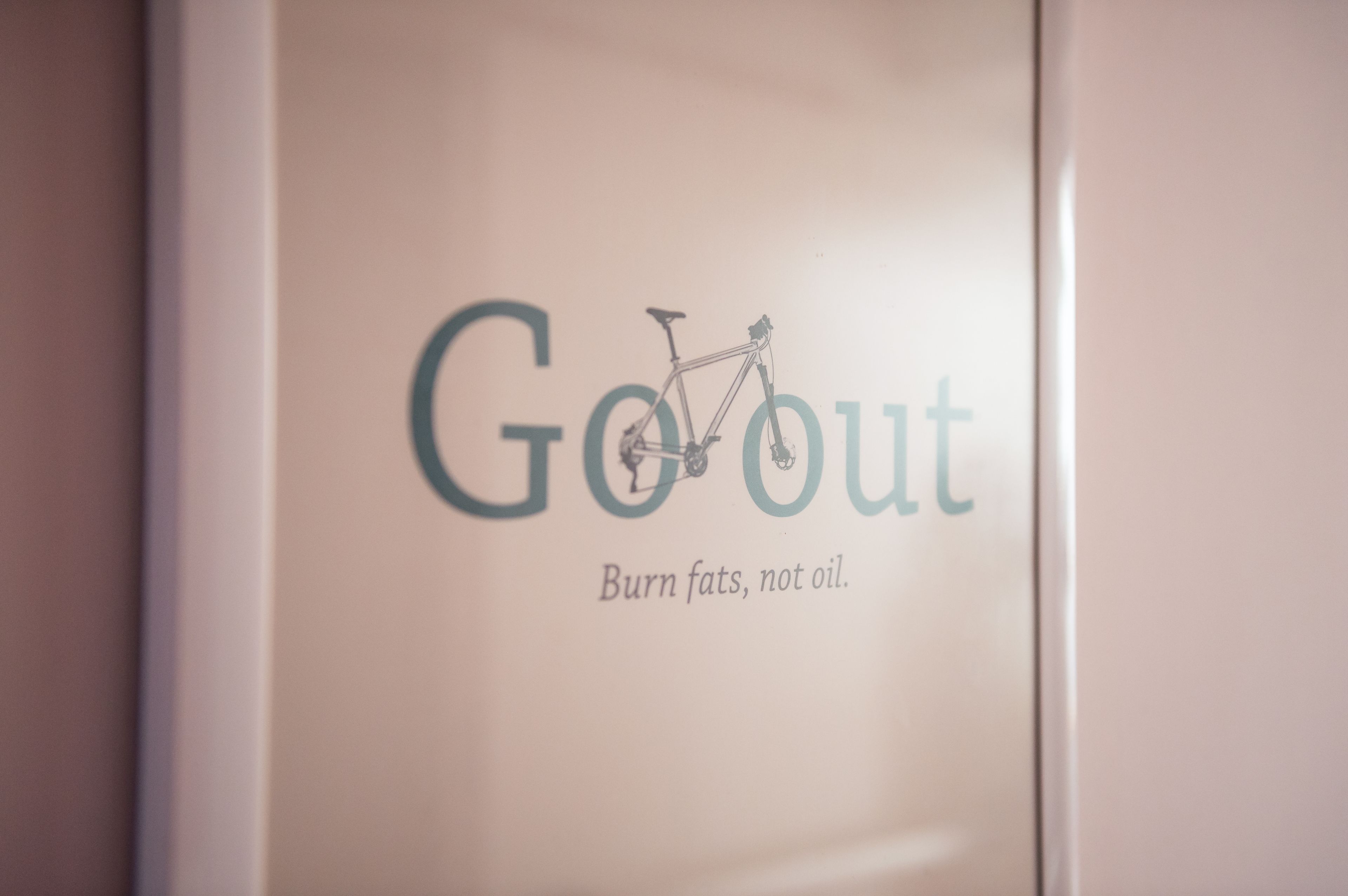 Un cartel con el texto 'GoOut' e ilustración de una bicicleta, sugiriendo un tema relacionado con ciclismo o actividades al aire libre.