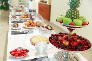 A buffet table with various food items including fruits, pastries, and a pie. - Ripamonti Residence & Hotel (Pieve Emanuele)