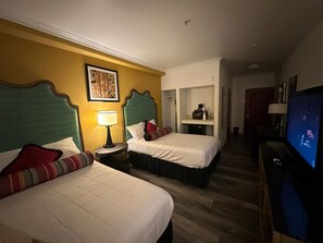 A hotel room with two beds, a television, a desk with a lamp, and a small kitchenette. - Howard Johnson by Wyndham Bakersfield (Bakersfield)