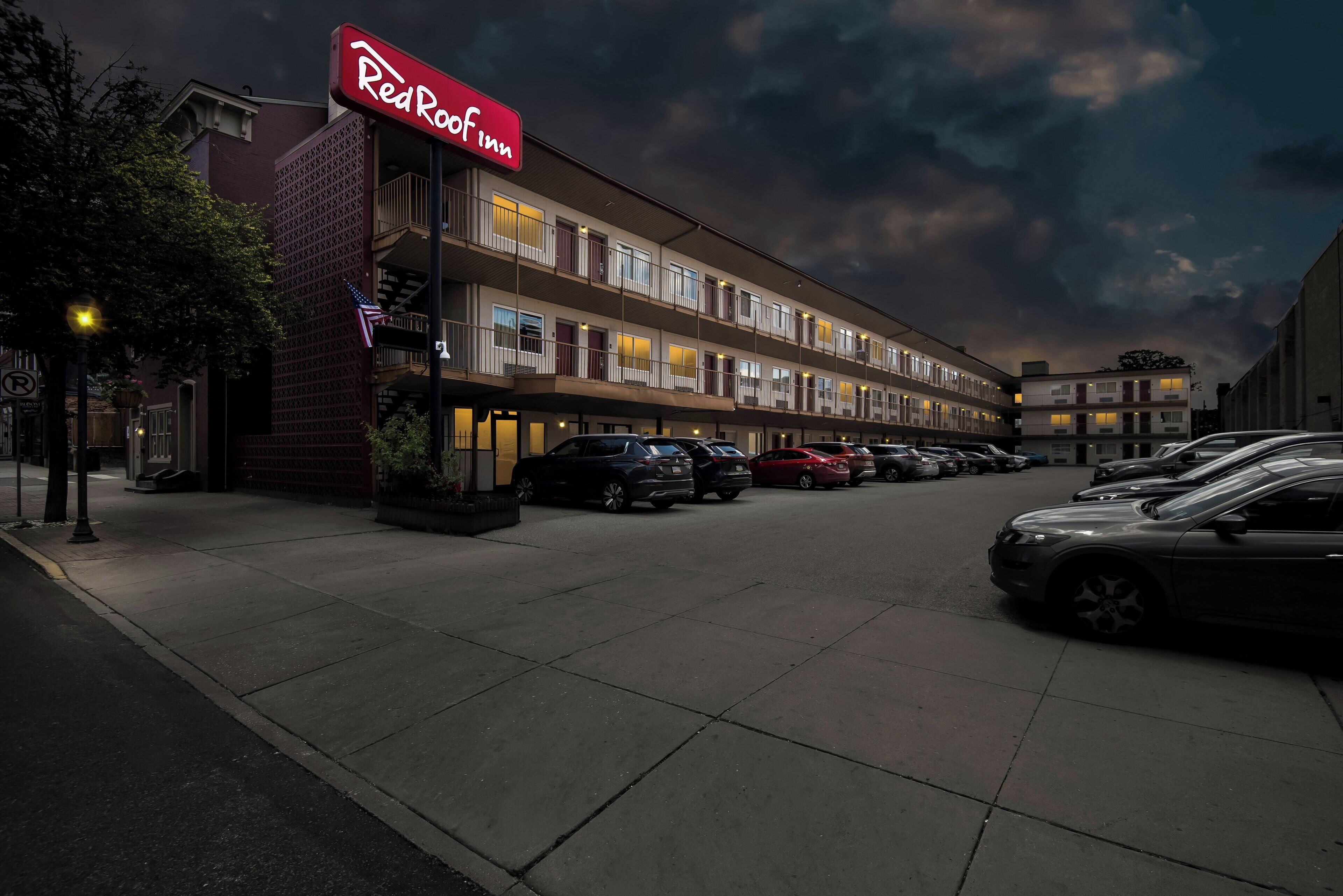 Un hotel Red Roof Inn con aparcamiento y varios coches estacionados.