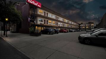 A Red Roof Inn with a parking lot and multiple cars parked.