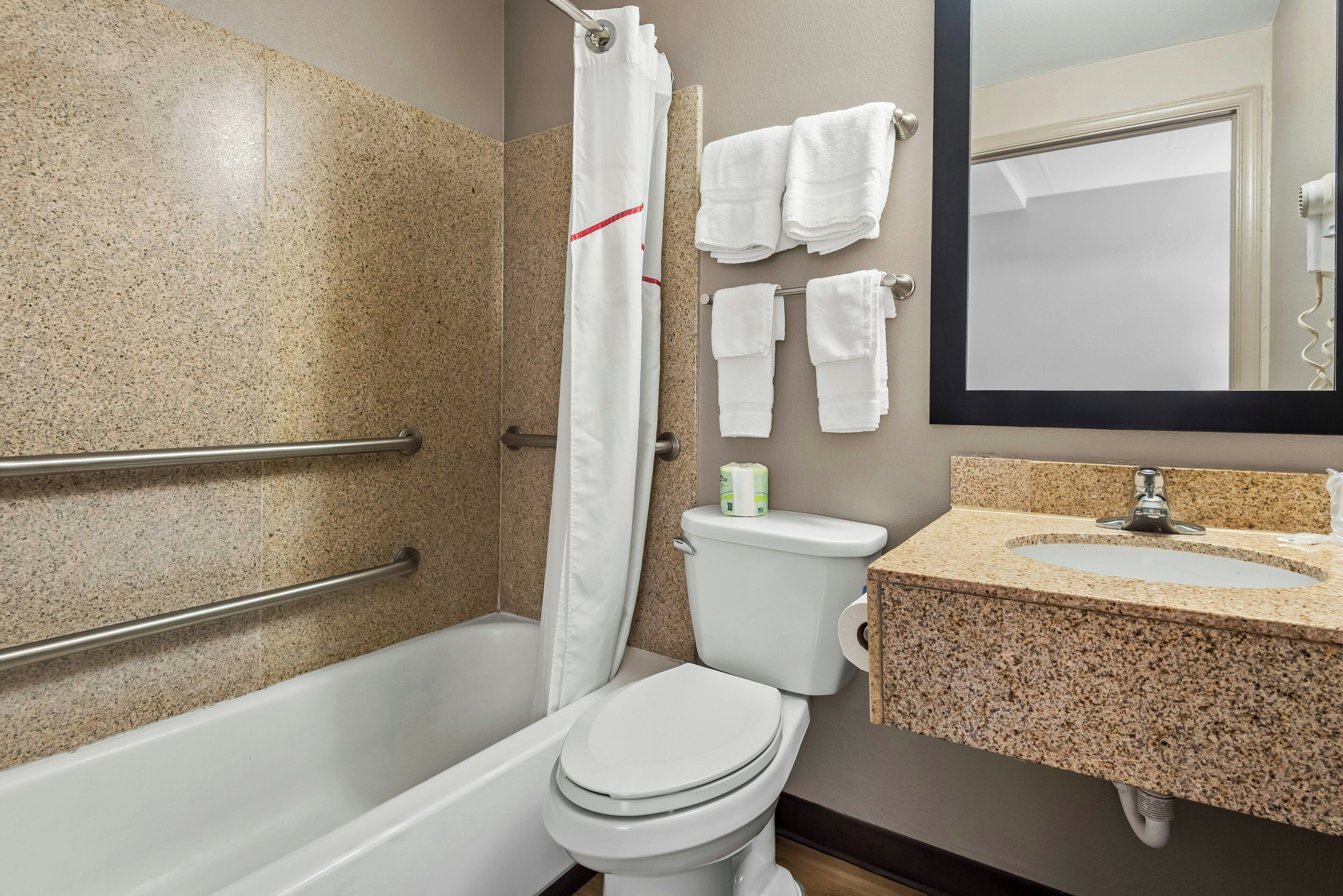 A bathroom with a bathtub, toilet, and sink.