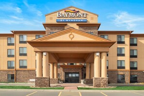 A Baymont by Wyndham hotel with a central entrance, stone facade, and multiple windows. - Baymont Inn and Suites by Wyndham Sturgis (Sturgis)
