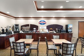 A breakfast area with a counter, seating, and kitchen appliances. - Baymont Inn and Suites by Wyndham Sturgis (Sturgis)