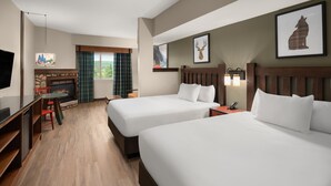 A hotel room with two beds, a fireplace, a TV, and a dining area. - Great Wolf Lodge Grand Mound (Centralia)