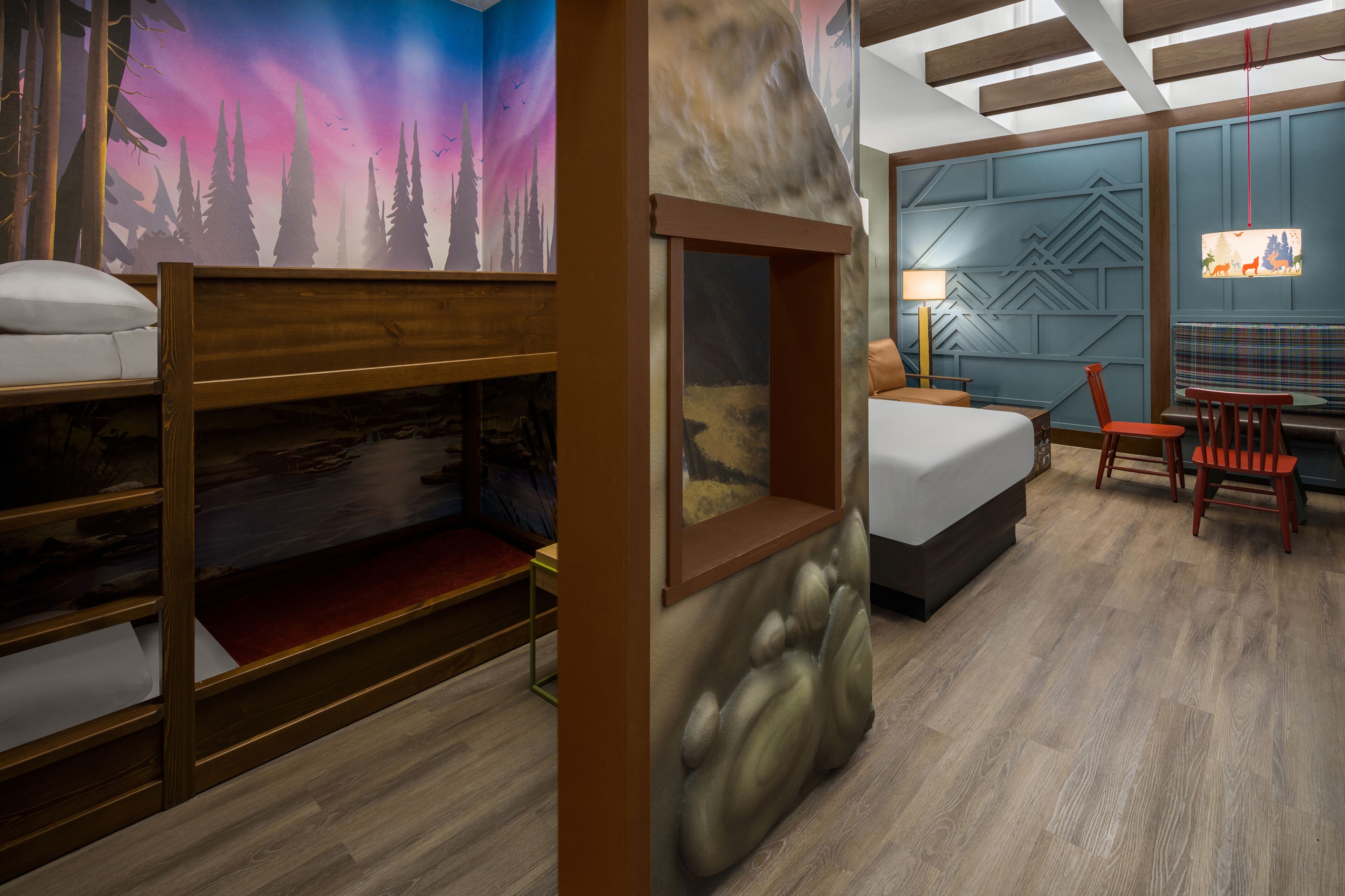A room with bunk beds, a desk, a chair, and a bed.