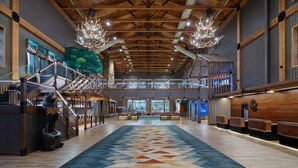 A spacious lobby with a high ceiling, wooden beams, and a patterned carpet. - Great Wolf Lodge Grand Mound (Centralia)