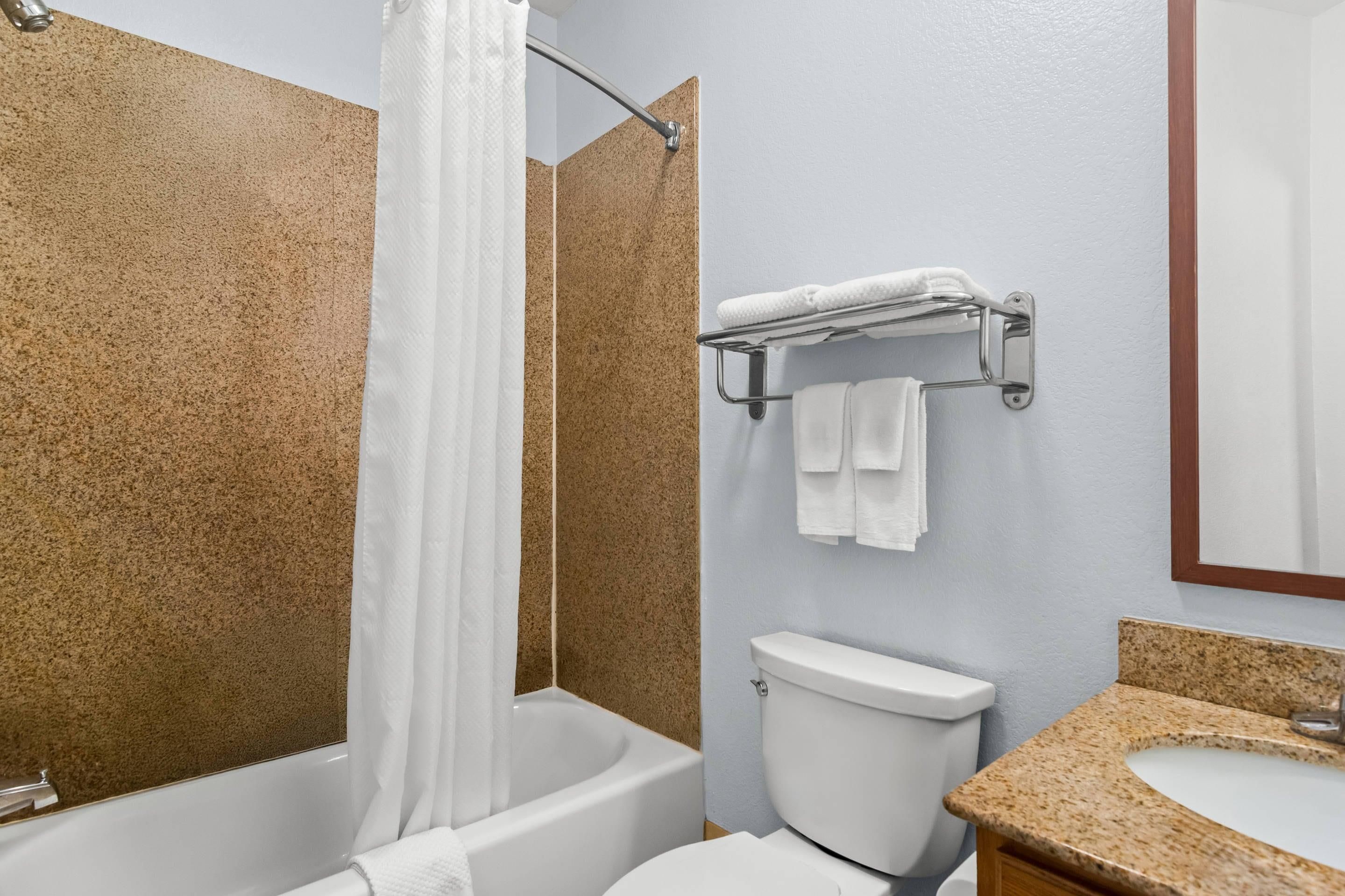A bathroom with a bathtub, toilet, and sink.